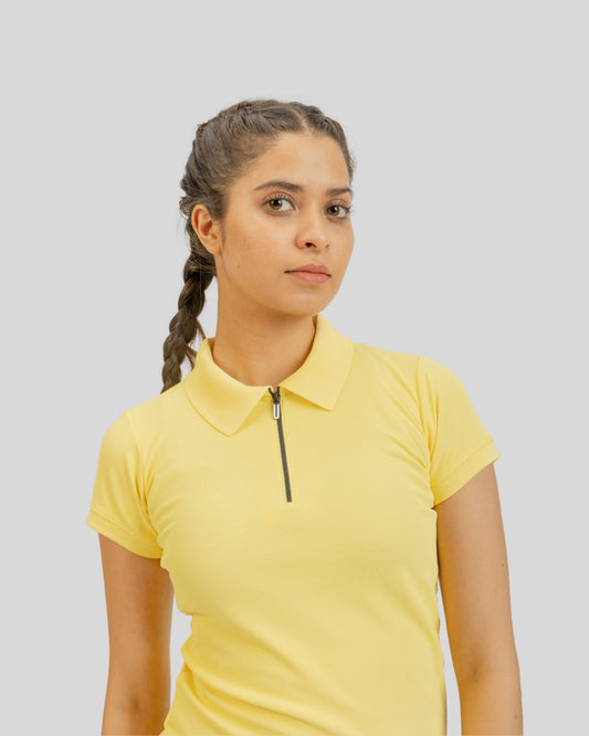 Woman wearing a yellow polo shirt with a zipper on a light gray background