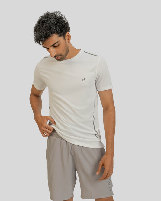 Man wearing a light gray t-shirt and shorts on a plain background