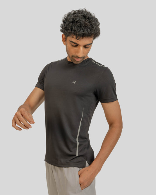 Man wearing a black athletic shirt with a logo on a light gray background