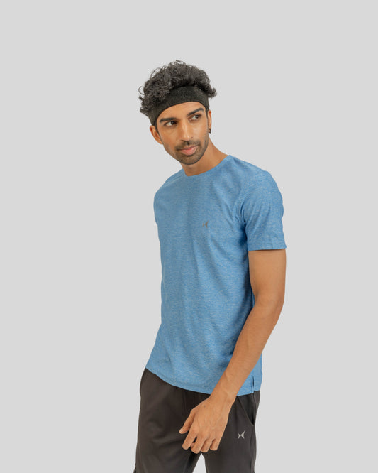 Man wearing a blue athletic shirt and black pants on a gray background