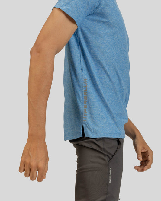 Person wearing a blue athletic shirt and gray shorts on a light gray background