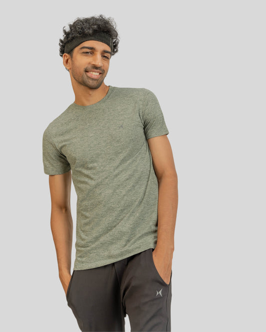 Man wearing a green athletic shirt and black pants on a gray background