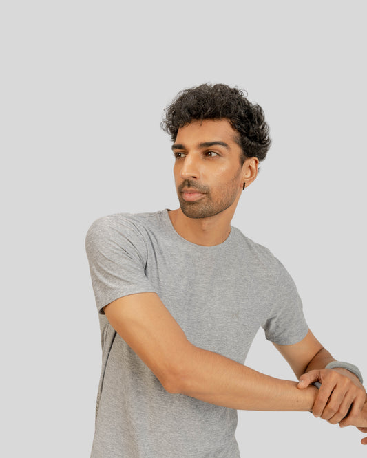 Man wearing a gray t-shirt against a light gray background