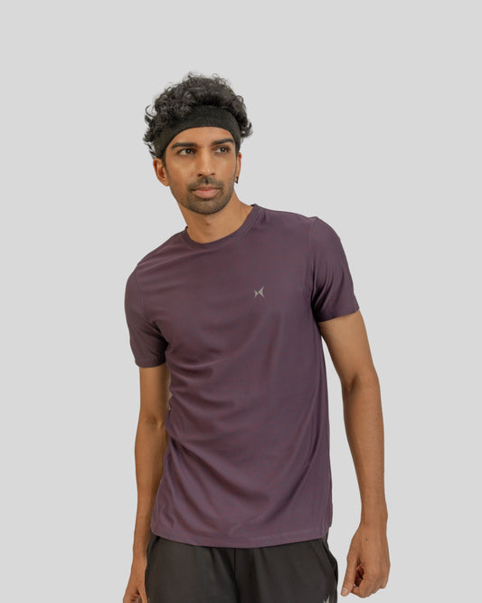 Man wearing a maroon athletic shirt on a light gray background