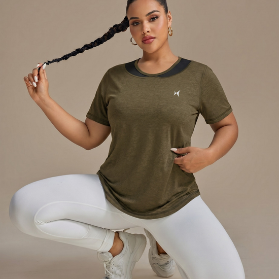 Woman wearing a green athletic shirt with a logo on a beige background