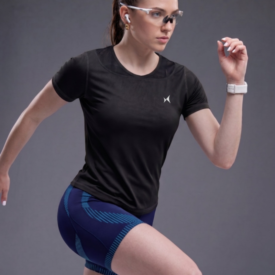 Woman in athletic wear posing against a gray background