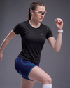 Woman in athletic wear posing against a gray background