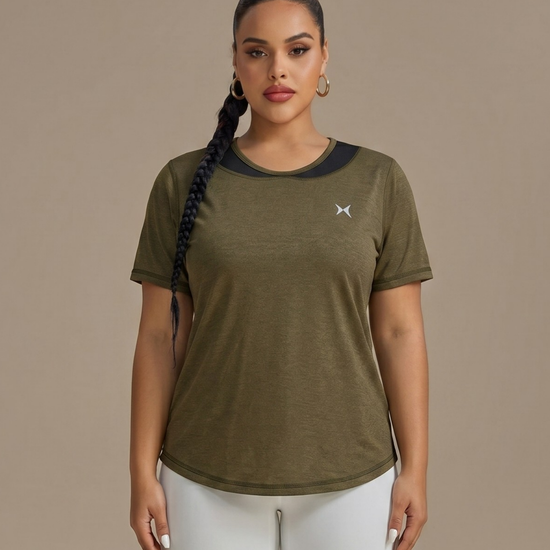 Woman wearing a green athletic shirt with a logo on a beige background