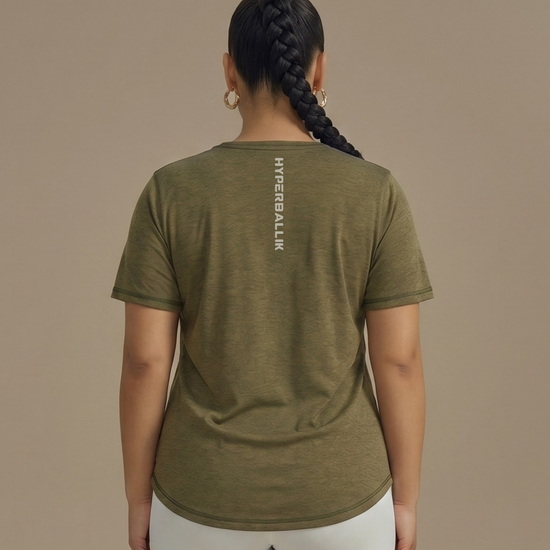 Person wearing an olive green t-shirt with a brand logo on the back against a beige background