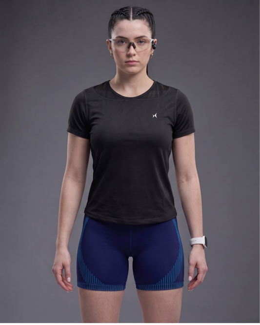 Person wearing a black athletic shirt and blue shorts on a gray background
