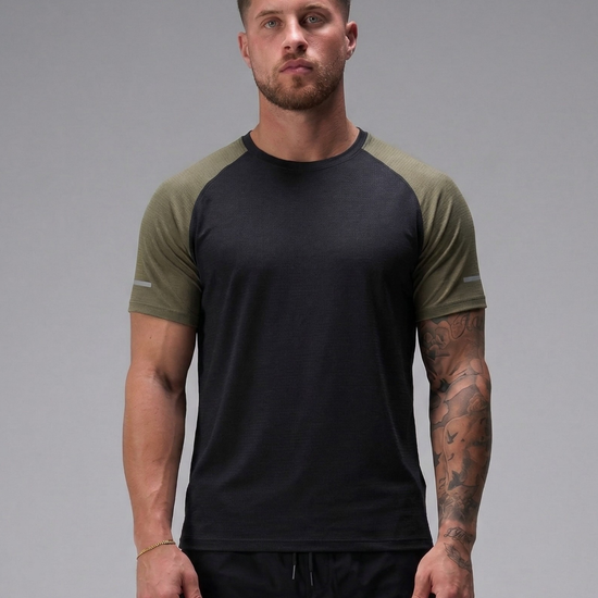 Man wearing a black and green t-shirt against a gray background