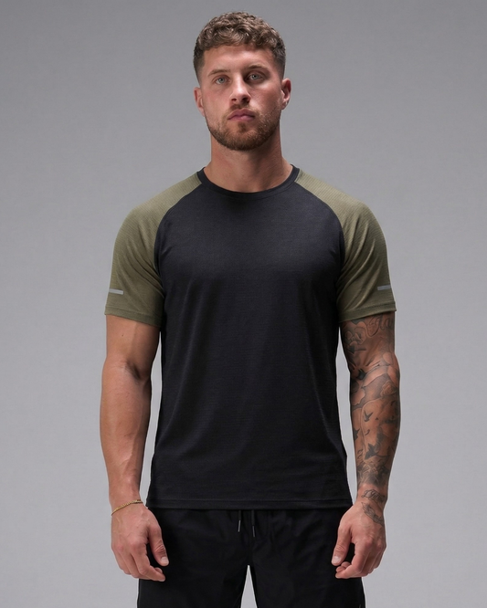 Man wearing a black and green t-shirt against a gray background