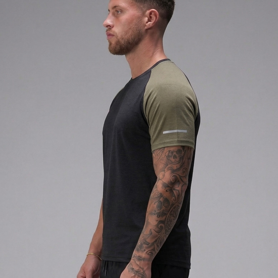 Man wearing a black and green t-shirt on a gray background