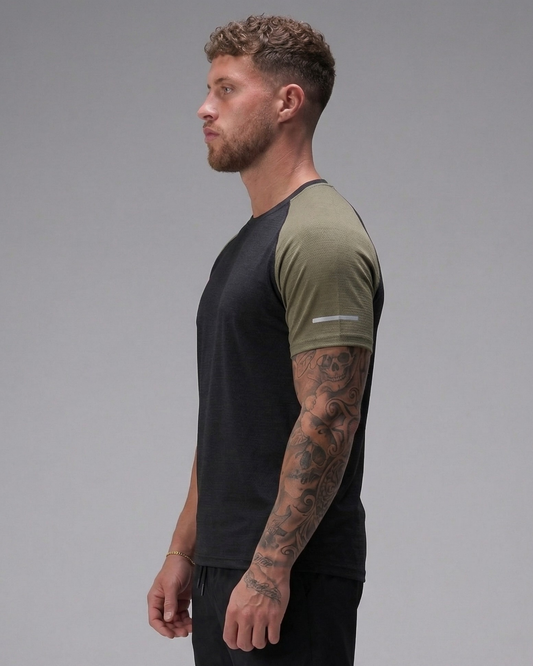 Man wearing a black and green t-shirt on a gray background