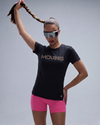 Person wearing a black 'MOVING' t-shirt and pink shorts with reflective sunglasses on a gray background