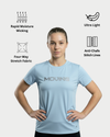 Woman wearing a light blue athletic shirt with text, standing against a white background with feature icons.