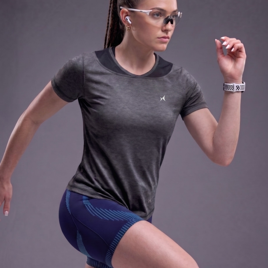 Woman in athletic wear posing against a gray background