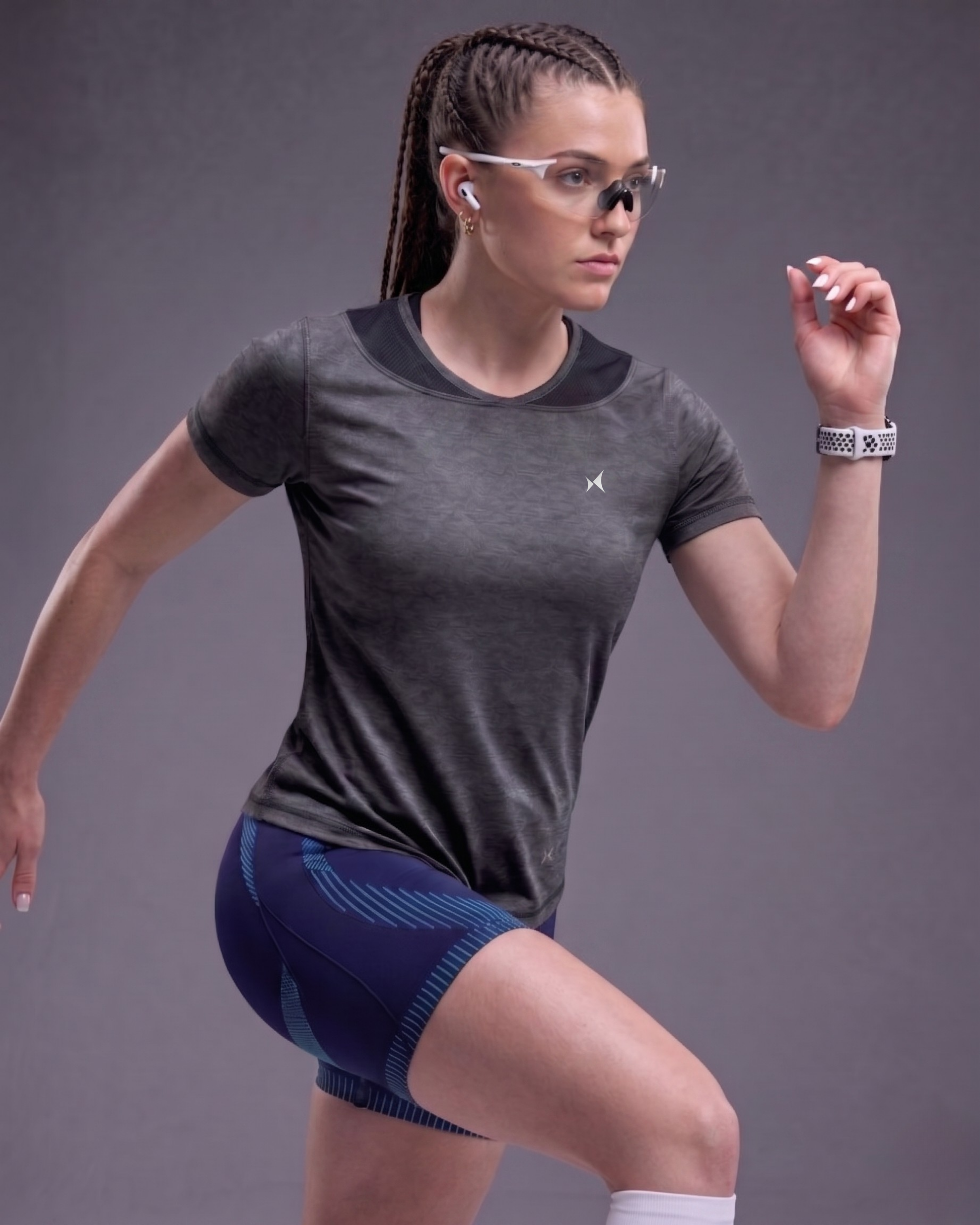 Woman in athletic wear posing against a gray background