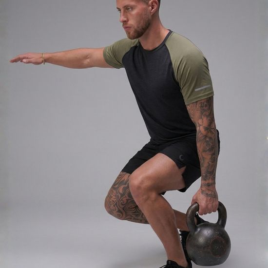 Man performing a kettlebell exercise against a gray background