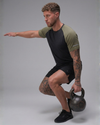Man performing a kettlebell exercise against a gray background