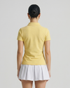 Person wearing a yellow polo shirt and white skirt on a plain background