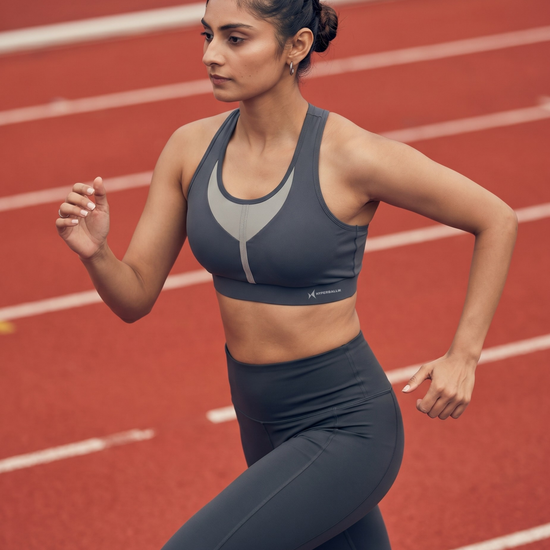 Woman running on a track wearing athletic gear