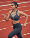 Woman running on a track wearing athletic gear