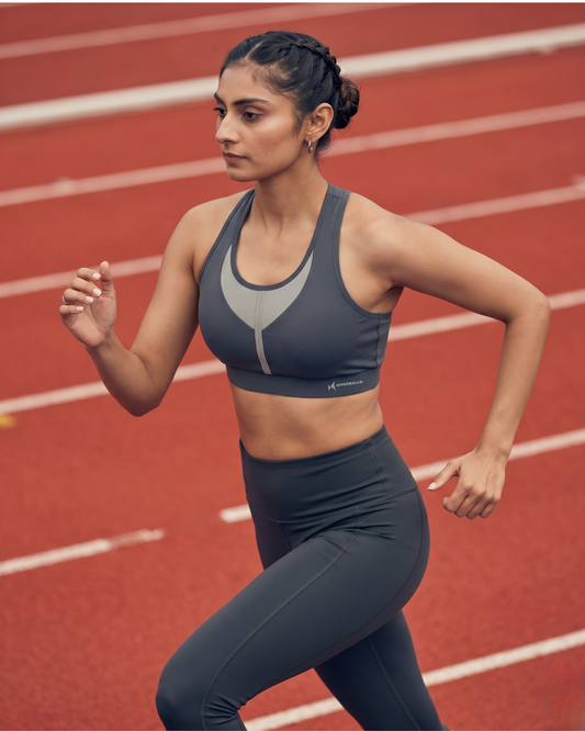 Woman running on a track wearing athletic gear