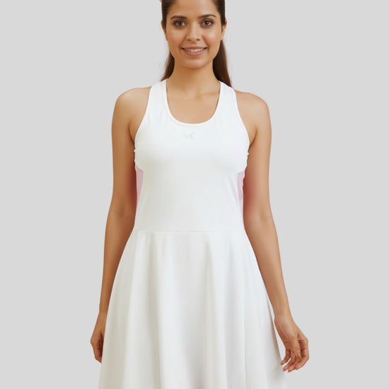 Woman wearing a white dress against a plain background