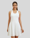 Woman wearing a white dress against a plain background