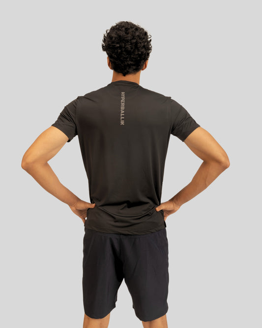 Person wearing a black athletic outfit with visible branding on a gray background