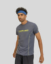 Man wearing a gray athletic shirt with a logo on a gray background