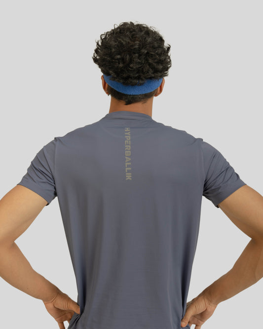 Person wearing a gray t-shirt with 'HYPERBALLER' branding on the back against a light gray background