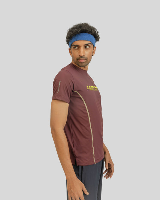Man wearing a maroon athletic shirt with a logo on a gray background