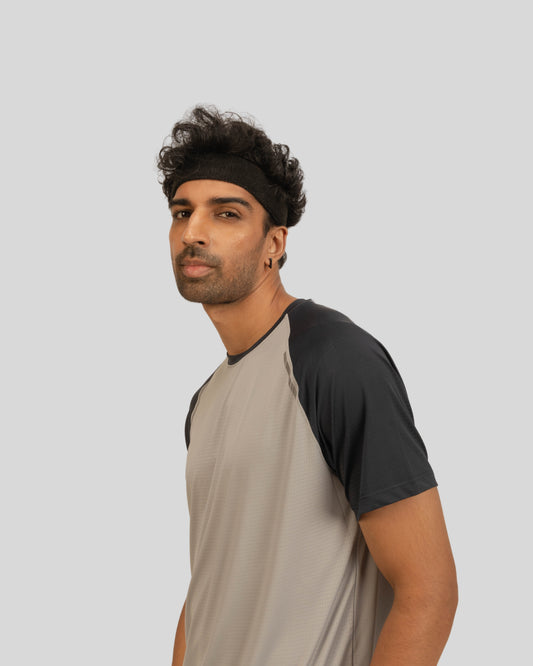 Man wearing a gray and black baseball shirt on a light gray background