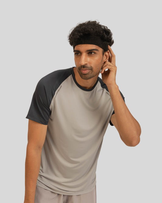 Man wearing a gray and black baseball shirt on a light gray background