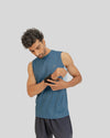 Man wearing a blue sleeveless shirt and black shorts on a light gray background