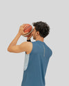 Person holding a basketball against a plain background
