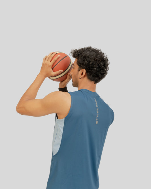 Person holding a basketball against a plain background