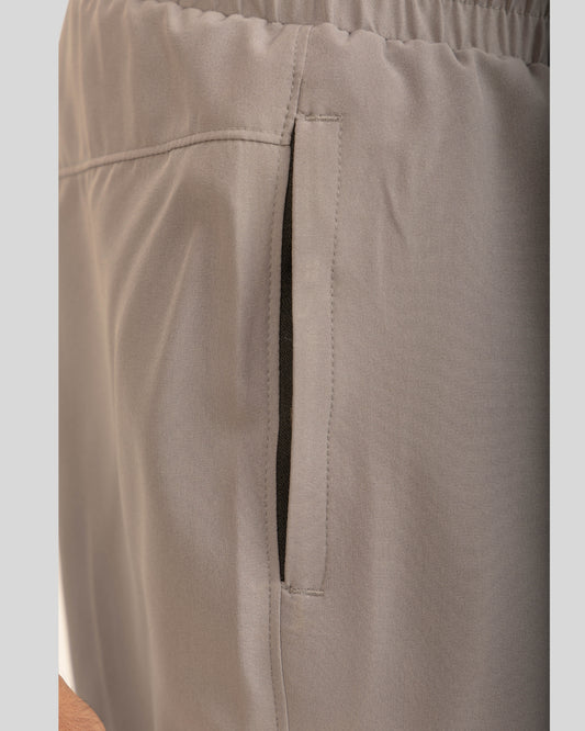Close-up of beige pants with a pocket on a light gray background