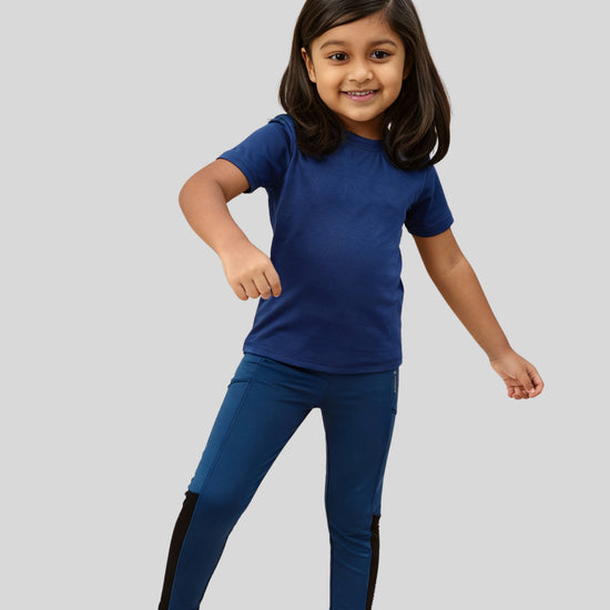 Child wearing a blue outfit with black accents on a gray background