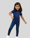 Child wearing a blue outfit with black accents on a gray background
