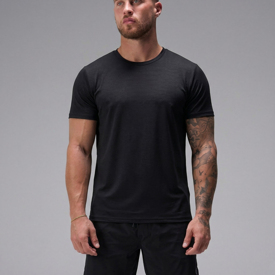 Man wearing a black t-shirt and shorts on a gray background
