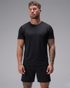 Man wearing a black t-shirt and shorts on a gray background