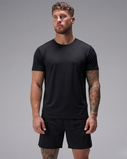 Man wearing a black t-shirt and shorts on a gray background