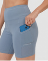  blue athletic shorts with a pocket holding a phone