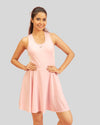 Woman wearing a pink sleeveless dress on a gray background
