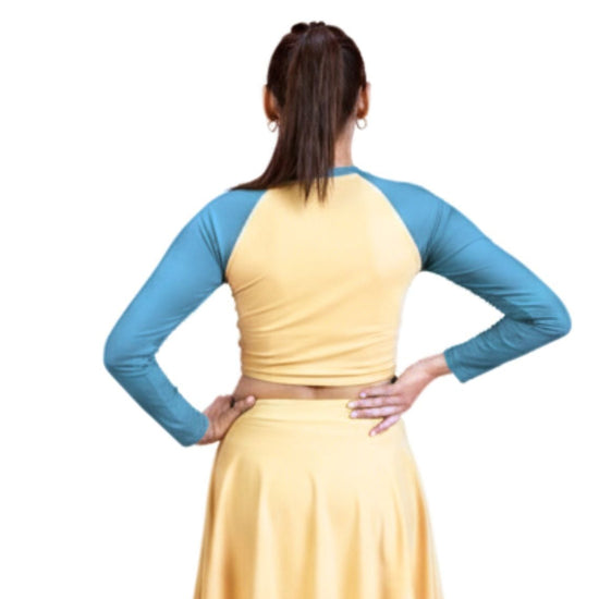 Woman wearing a yellow dress with blue sleeves on a white background