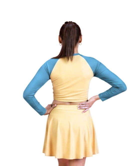 Woman wearing a yellow dress with blue sleeves on a white background