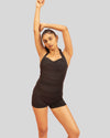 Woman wearing a black swimsuit against a gray background